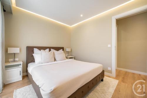une chambre avec un grand lit avec des draps blancs dans l'établissement Modern Appartment, Central, 10 Min Walk to Beach, à Vallauris