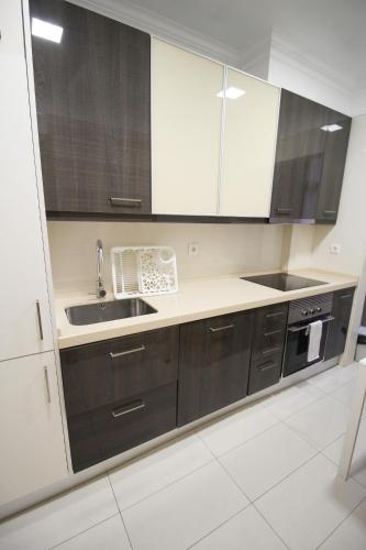 a kitchen with black and white cabinets and a sink at Oriente DNA Studios V in Lisbon