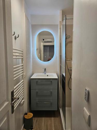 une salle de bain avec un lavabo et un miroir dans l'établissement O Fil de l'eau Deauville piscine chauffée, à Deauville