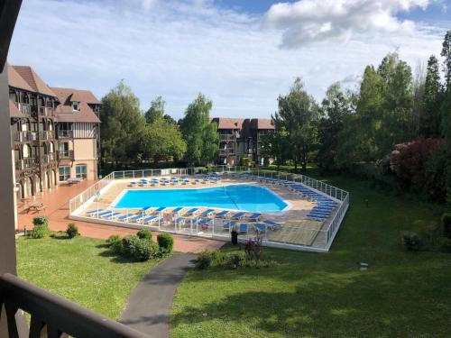 une vue d'une piscine dans un complexe hôtelier dans l'établissement O Fil de l'eau Deauville piscine chauffée, à Deauville