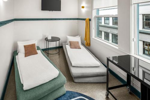 a room with two beds and a table and a window at Silverbow Inn in Juneau