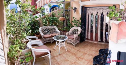 a patio with chairs and a table and some plants at La Finca in Oropesa del Mar
