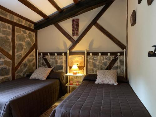 a bedroom with two beds in a attic at Apartamento Rustico El Cerezo in Lubayo