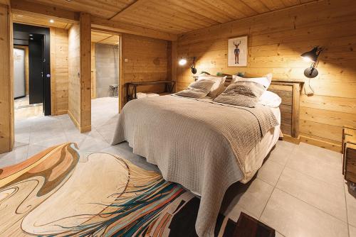 une chambre avec un lit dans une cabane en bois dans l'établissement Les Chalets-Hôtel de la Croix-Fry, à Manigod