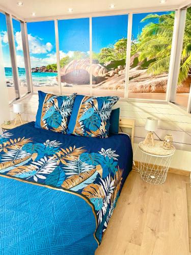 - un lit bleu dans une chambre avec une grande fenêtre dans l'établissement Calme et Intimité proche Avignon Piscine options au choix privée ou partagée de juin à octobre, à Morières-lès-Avignon