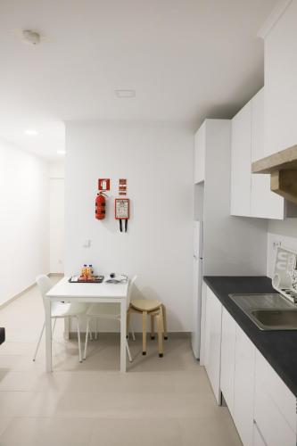 a white kitchen with a white table and chairs at Oriente DNA Studios V in Lisbon