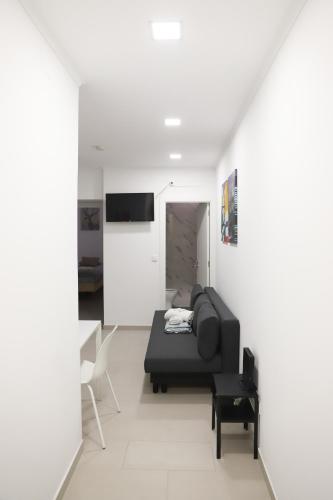 a living room with a black couch and a tv at Oriente DNA Studios V in Lisbon