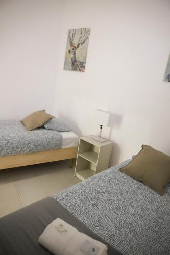 a bedroom with two beds and a night stand at Oriente DNA Studios V in Lisbon