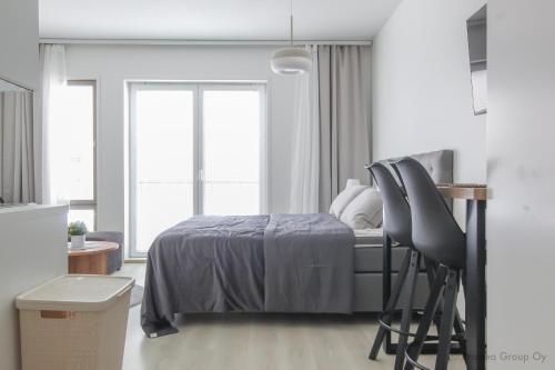 - une chambre avec un lit et deux chaises dans l'établissement Pramea Apartments Holvi, à Kuopio