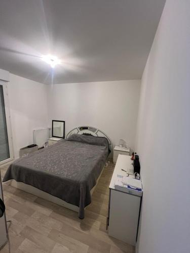 une chambre avec un lit et une table dedans dans l'établissement Appartement à Paris, à Vigneux-sur-Seine