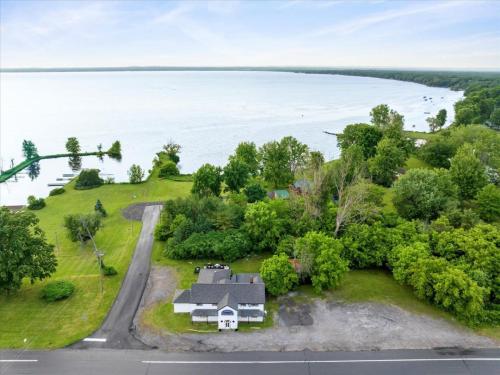 an aerial view of a house on a hill next to the water at Whitewater The Genoa on Oneida Lake Sleeps 8 in Canastota