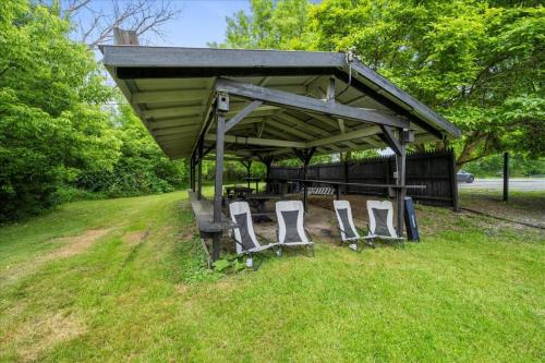 a group of chairs under a pavilion in the grass at Whitewater The Genoa on Oneida Lake Sleeps 8 in Canastota