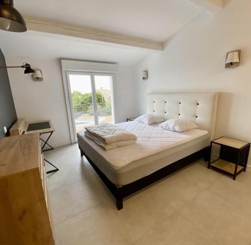 une chambre blanche avec un grand lit et une fenêtre dans l'établissement Superbe vue mer et Estérel, Villa Neuve pour 8-10 Personnes, Clim, Piscine, à Saint-Raphaël