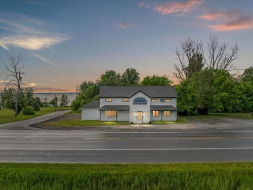 a white house sitting on the side of a road at Whitewater The Genoa on Oneida Lake Sleeps 8 in Canastota
