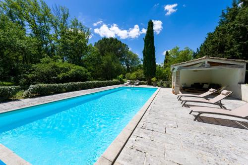 une piscine avec des chaises longues et un gazebo dans l'établissement Mas authentique à Eygalières, à Eygalières
