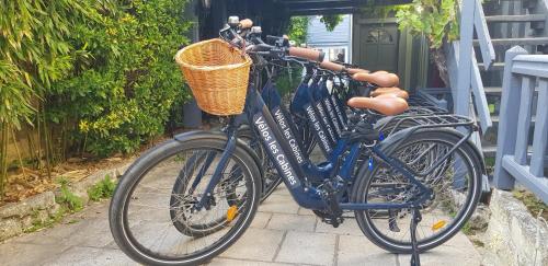 un vélo bleu avec un panier garé à côté d'une maison dans l'établissement Les Cabines, à Houlgate