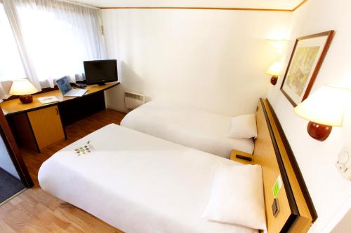 a hotel room with two beds and a desk at Campanile Nevers Nord - Varennes-Vauzelles in Varennes Vauzelles