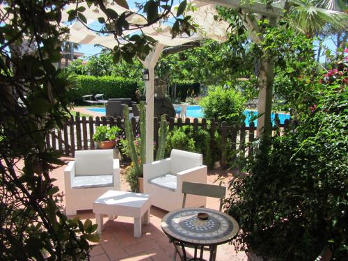a patio with white chairs and a table and a fence at Sole e Sale B&B in San Cataldo