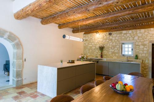 une cuisine avec une table avec un bol de fruits dessus dans l'établissement Mas authentique à Eygalières, à Eygalières
