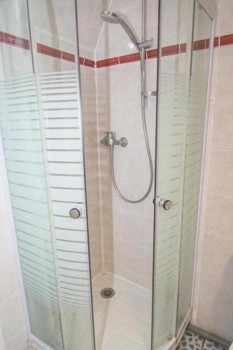 une salle de bain avec une douche avec une porte vitrée dans l'établissement Gîte Gîtes de France 4/6 personnes à Cubières, à Cubières