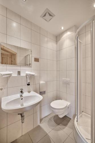 a white bathroom with a sink and a toilet at AREA 47 - Tirol in Ötztal-Bahnhof