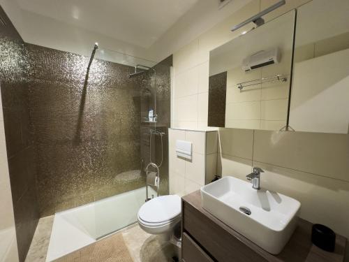 a bathroom with a sink and a toilet and a shower at Istria Symphony Apartment in Labin