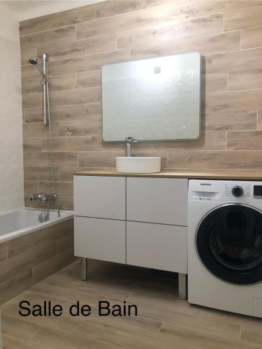 La salle de bains est pourvue d'un lave-linge et d'un miroir. dans l'établissement CARRE D'OR - Appartement 3P - Antibes Centre - Carré d'Or, à Antibes