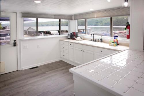 a kitchen with white cabinets and a large window at The Mooring in Hammondsport