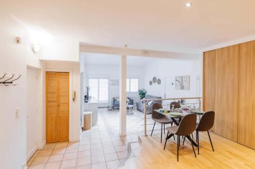 une cuisine et une salle à manger avec une table et des chaises dans l'établissement Sublime Appartement Parisiens, à Paris