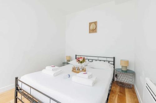 Cette chambre blanche dispose d'un lit orné de fleurs. dans l'établissement Sublime Appartement Parisiens, à Paris