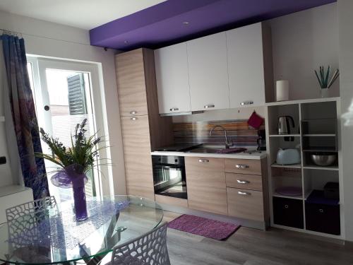 a kitchen with a glass table with a vase on it at "CASABANA" - relax tutto l'anno - giardino - piscina Top in Malcesine
