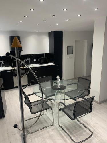 une table et des chaises en verre dans une pièce dans l'établissement L' orchidée de Lectoure, à Lectoure