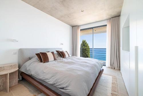 una camera da letto con un letto grande e una grande finestra di Villa Neuve, proche Monaco a Roquebrune-Cap-Martin