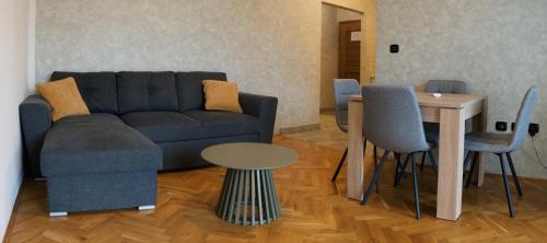Una sala de estar con un sofá azul y una mesa. en Apartments Villa Marta, en Opatija