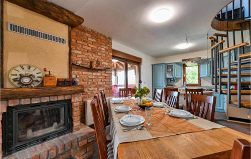 a dining room with a table and a fireplace at Nice Home In Zelezna Gora With Sauna in Grabrovnik