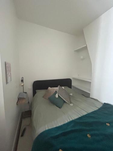 une chambre avec un lit avec deux oreillers dessus dans l'établissement 1 BDR Cosy Parisian Appartment, close to Marais (Paris 11ème), à Paris