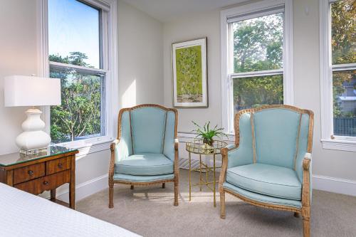 two chairs and a table in a room with windows at The West Lane Inn in Ridgefield