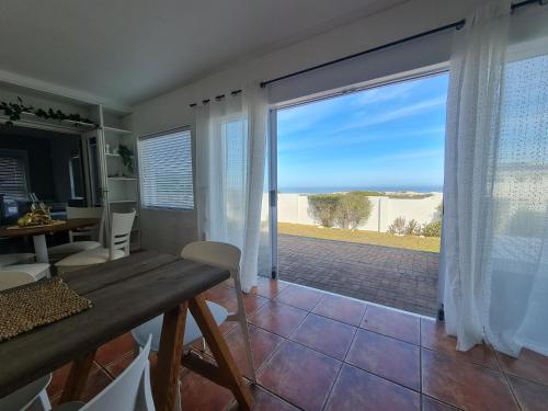 a dining room with a view of the ocean at Urban Sole Beach House in Yzerfontein