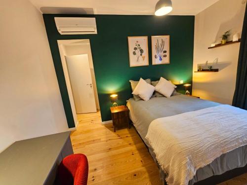 une chambre avec un lit et un mur végétal dans l'établissement Sous les toits dans les nuages, à Dax