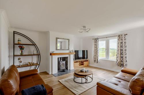 un soggiorno con divano e camino di Berryrigg Cottage a Dumfries