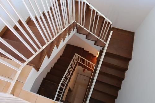 a staircase in a house with wood and white railings at O Jardim do Vinho, AC in Praia