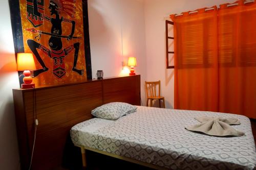 a bedroom with a bed and a painting on the wall at O Jardim do Vinho, AC in Praia