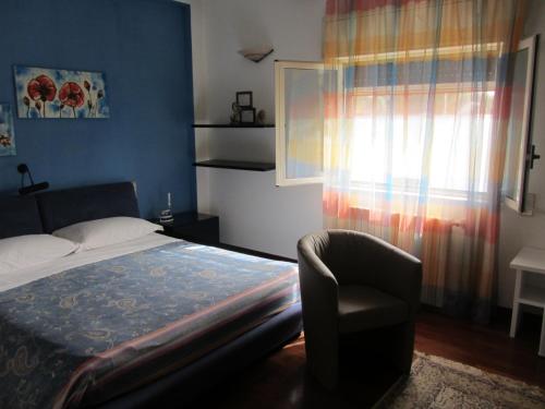 a bedroom with a bed and a chair and a window at Sole e Sale B&B in San Cataldo