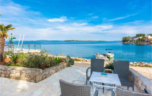a patio with a table and chairs next to the water at 3 Bedroom Pet Friendly Home In Zman in Žman