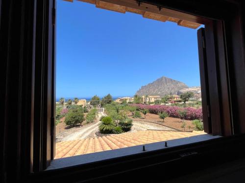 a window with a view of a garden with mountains at Villa Lea in Custonaci