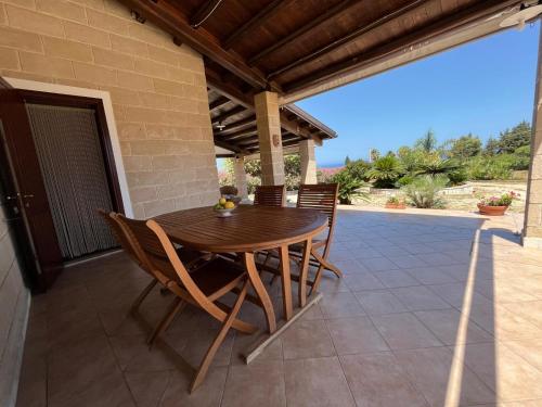 a wooden table and chairs on a patio at Villa Lea in Custonaci