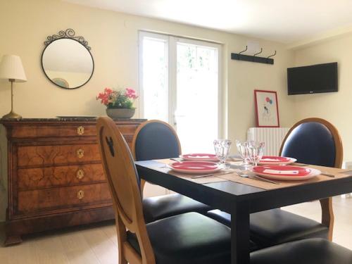 a dining room table and chairs with a table and a mirror at F2 NEUF & CALME 15 min Disneyland, 25 min Paris in Thorigny-sur-Marne