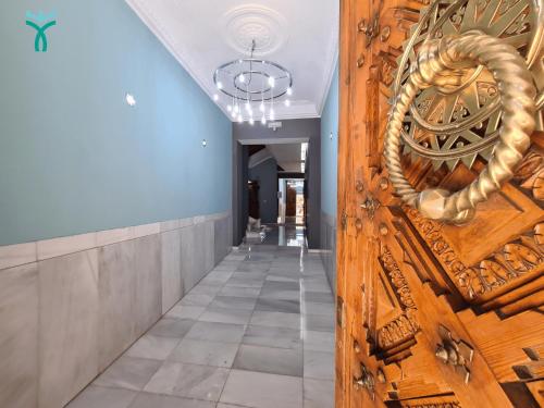 a hallway with a wooden door with a rope on it at Dos Torres Retiro Urbano en Alfonso I in Zaragoza