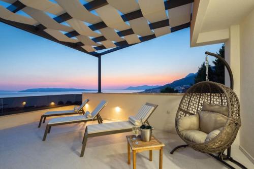 a balcony with chairs and a view of the ocean at Luxury Penthouse - Views, Hot Tub & Pool in Makarska