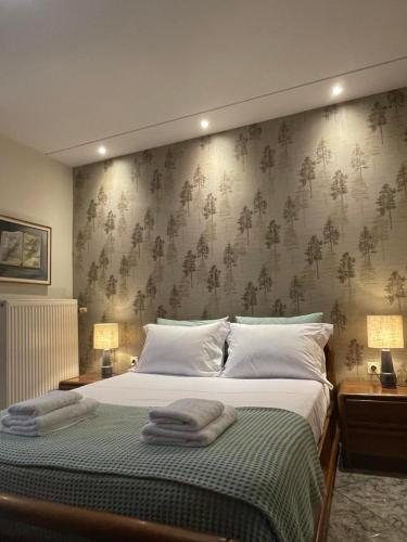 a bedroom with a large bed with towels on it at Palio Luxury Apartment in Paleo Tsifliki